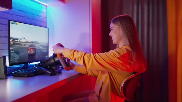 Woman playing the race. Woman having fun while driving on car racing simulator