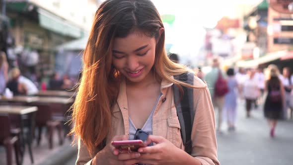 Young Tourist Using a Mobile Phone in Street Market