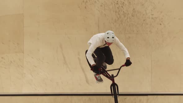 A Man Riding on the Plywood Ramps on His Sports Bike and Performing Tricks in the Air Takes Off His