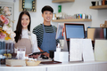 A coffee shop business owner greets customers with a smiling face. - PhotoDune Item for Sale