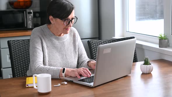 Retired Woman Using Laptop for Remote Work