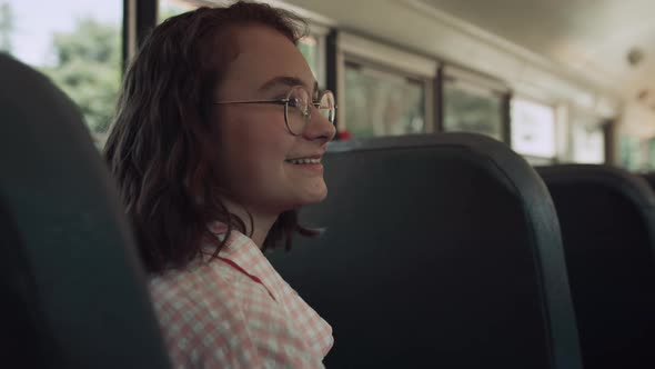 Smiling Teen Girl Sitting School Bus Talking with Friends