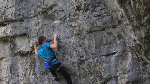 A man rock climbing up a mountain.