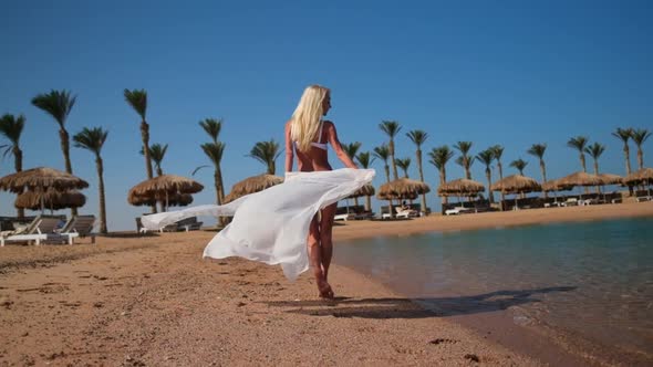 Young Fashion Woman Wearing Pareo Walking on the Beach