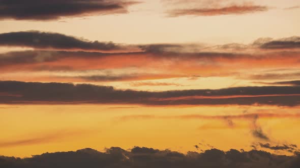 Time lapse with fast moving clouds on blue sky at sunset.