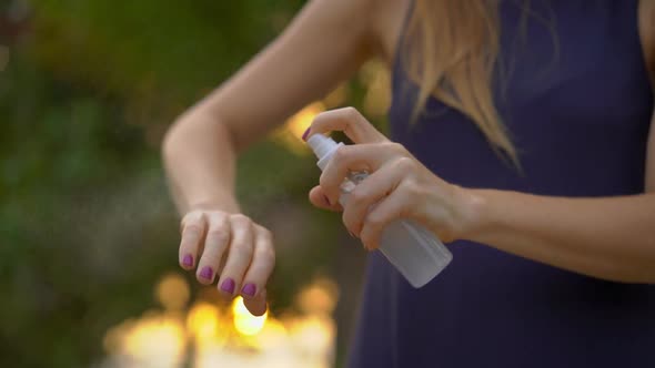 Superslowmotion Shot of a Beautiful Young Woman Applying an Antimosquito Repellent Spray on Her Skin