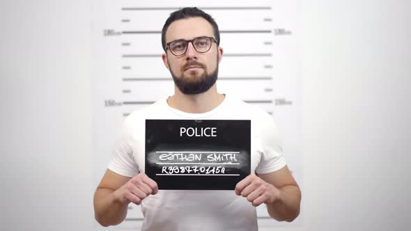 Mugshot of Young Guilty Bearded Man at Police Station