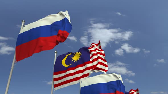 Flags of Malaysia and Russia Against Blue Sky