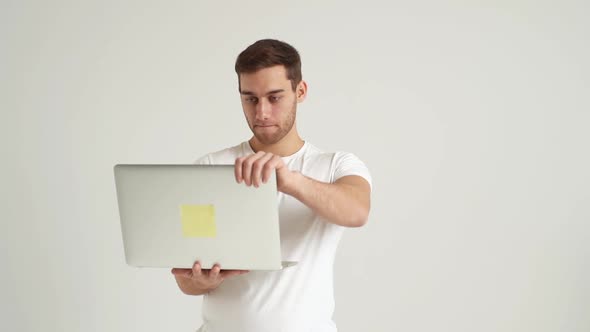 Studio Portrait of Frustrated Young Man Having Problems Working Using Laptop Disappointed with