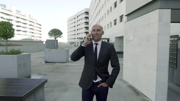 Attractive Bald Man in Office Suit Talking Via Smartphone