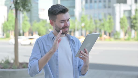 Video Call on Tablet By Young Man Standing Outdoor
