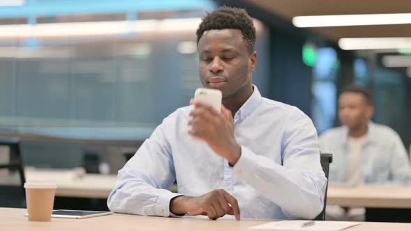 African Businessman Talking on Smartphone in Office