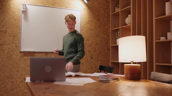 Man Having Conference Video Call on Laptop Explaining Something on Whiteboard
