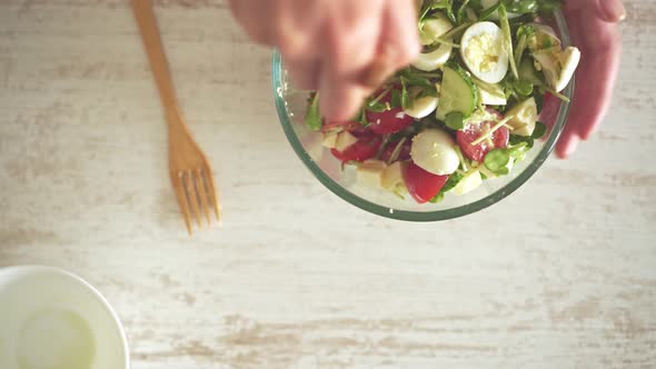 Person In The Kitchen In A Brown Apron Mixes Fresh Micro Greens