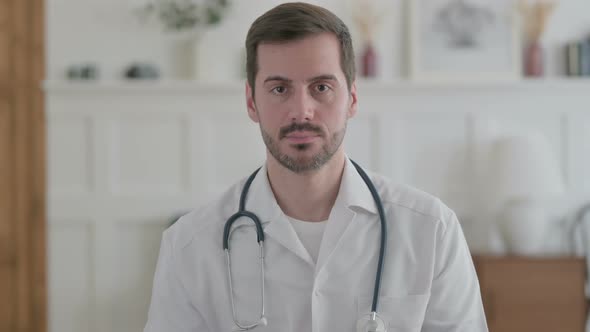 Portrait of Serious Young Doctor Looking at the Camera