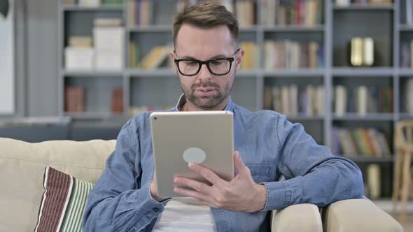 Portrait of Ambitious Young Man Using Tablet on Sofa