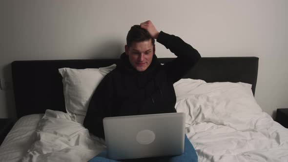 Excited Man Checking Email Reading Great News on Laptop in Bedroom