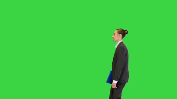 Young Office Manager Walks with Documents in His Hand on a Green Screen Chroma Key