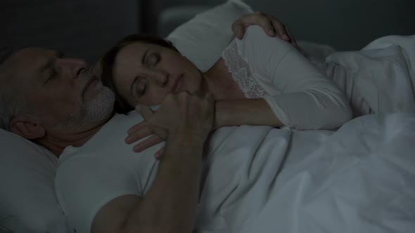 Elderly Husband and Wife Sleeping in Bed, Woman Put Head on Man Chest, Loving