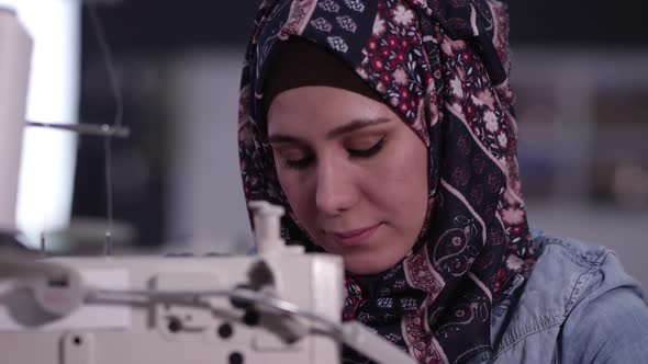 Ethnic woman sewing American Flag
