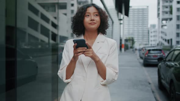 Young Attractive Indian Businesswoman using a mobile phone.