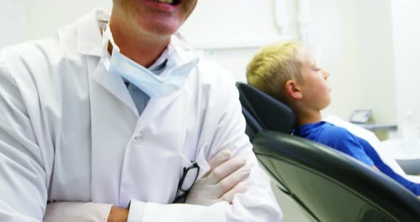 Portrait of smiling dentist standing with arms crossed