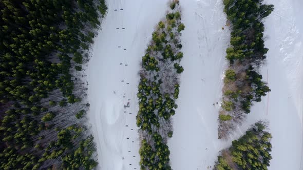Drone flight over a group of people skiing in the ski resort during winter season. 