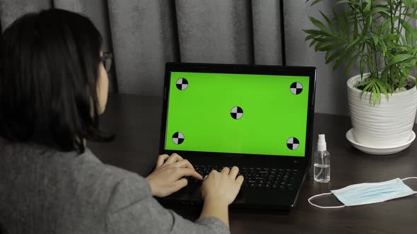 Woman Are Typing on Laptop Keyboard with Green Screen, Chroma Key. Distance Work