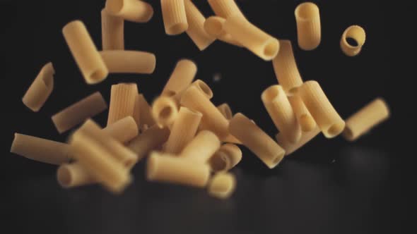 Super Slow Motion Drop Dry Pasta on a Black Background