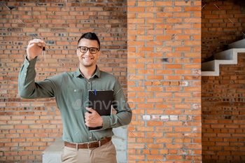 overjoyed real estate agent with folder holding keys from new house and looking at camera