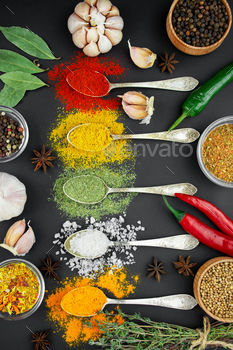A variety of spices and herbs on a dark table. Cooking background.Table background menu