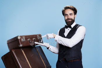 ncierge hospitality concept, ringing for assistance. Male bellhop or employee helping with baggage, luxury formal occupation.
