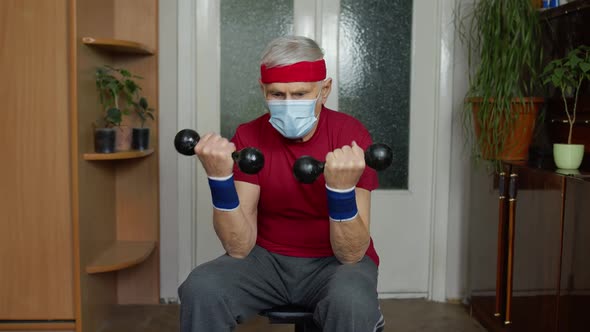 Senior Mature Grandfather Man in Sportswear Doing Weightlifting Dumbbell Exercising at Home