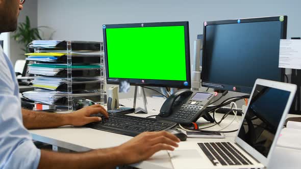 Male executive working on laptop and computer