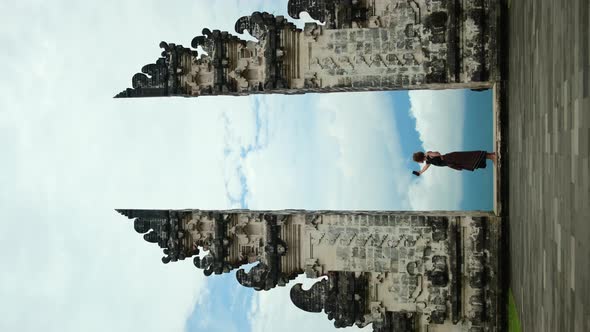 Scenery Vertical View on Dancing Female Blogger Tacking Selfies Near Famous Bali Gates Indonesia