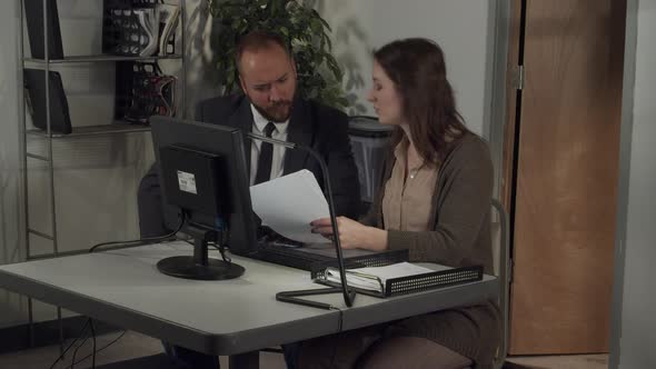 Male office worker works with female office worker discussing a project