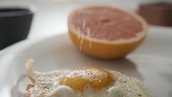 Short Video in Slow Motion of Fine Salt Being Topped on Sunny Side Up Egg