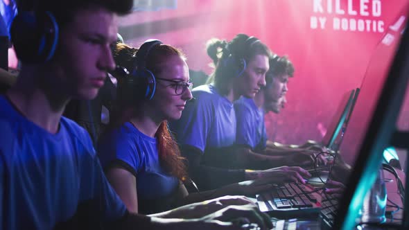 Focused Men and Women Playing Video Game During Competition