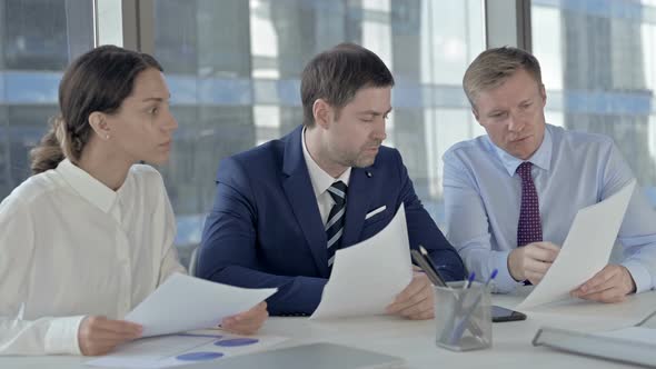 Executive Business People Discussing Things Through Documents on Office Table