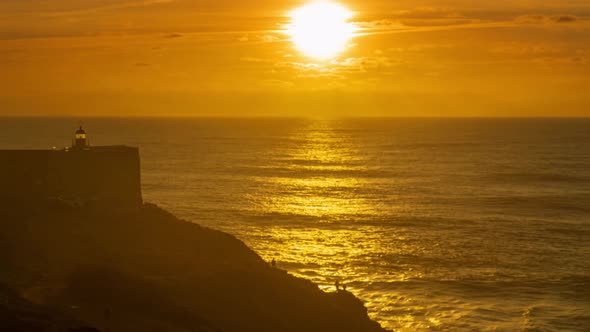 Lighthouse on a Cliff with a Fortress at Sunset