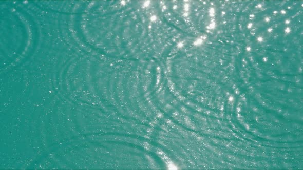 Droplets Fall Into Water Creating Small Circles of Waves