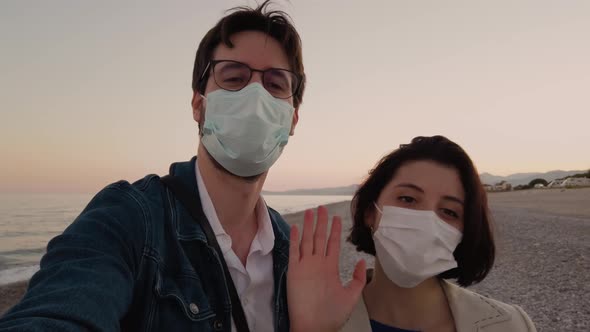 Couple takes a selfie on the beach with a mask