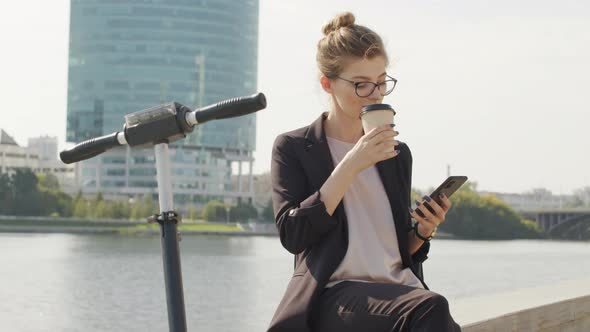 Business-Like Woman Sitting On Bridge By River