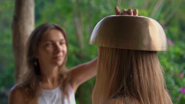 Superslowmotion Shot of a Woman Master of Asian Sacred Medicine Performs Tibetan Bowls Healing