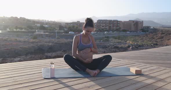 Pregnant woman doing yoga outdoor - Meditation and maternity concept