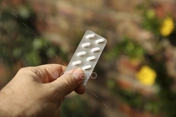 Person holding out a medicine blister pack