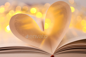 Heart from book pages on light background, close up