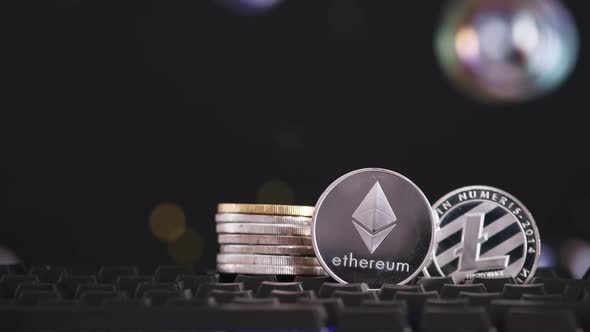 Cryptocurrency Ethereum and Litecoin on a Black Background with Flying Soap Bubbles