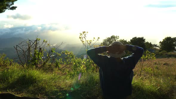 Man Hermit Meeting Up Sun Rise on the Edge of Mountains. Doing Meditation in Sun Light.