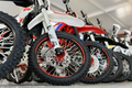 There are many colorful motorcycles for sale in the exhibition hall. Wheels close-up. - PhotoDune Item for Sale